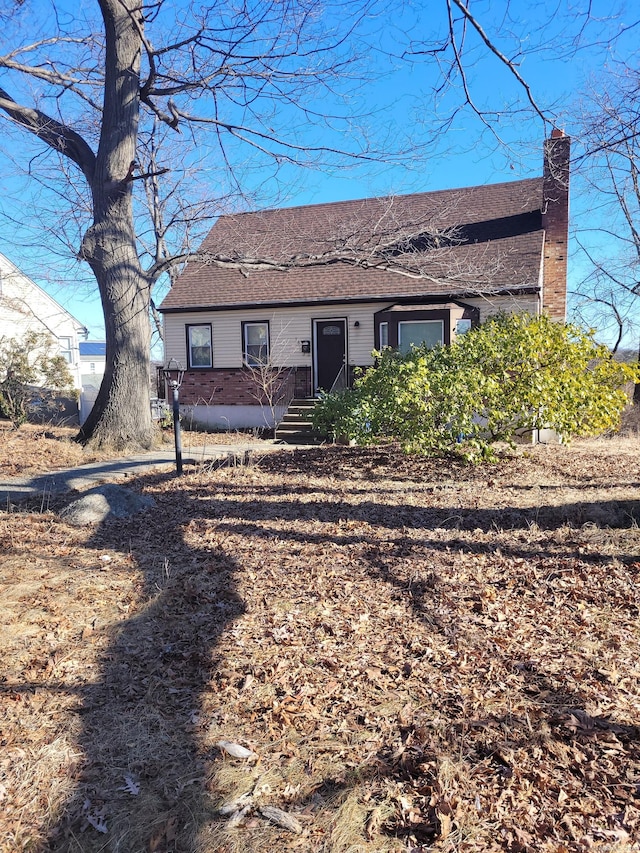 view of front of home with roof with shingles and a chimney