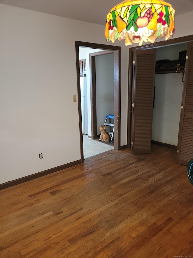 spare room featuring baseboards and wood finished floors