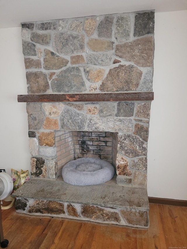 room details with a fireplace, wood finished floors, and baseboards