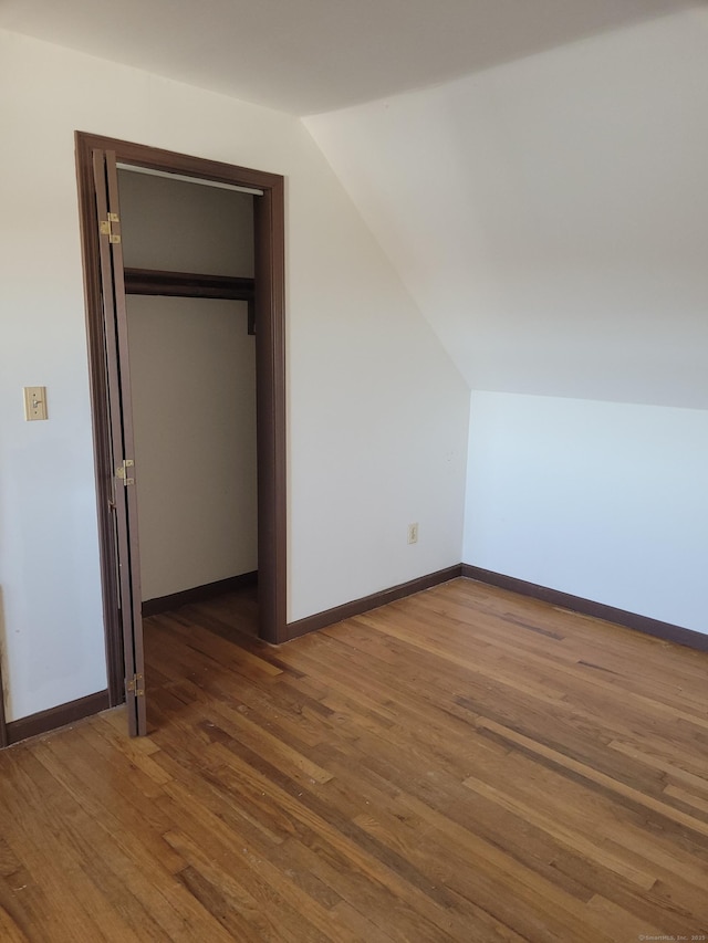 bonus room with lofted ceiling, baseboards, and wood finished floors