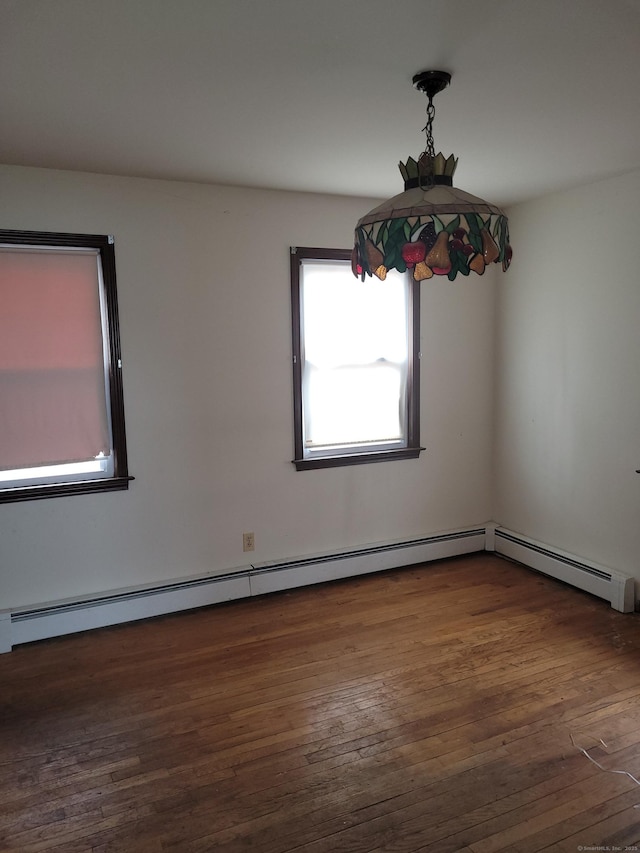 spare room with a baseboard radiator and wood finished floors