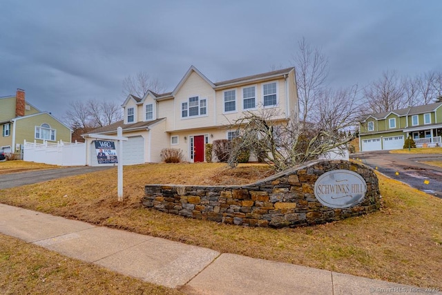 view of front of home featuring a garage, driveway, a residential view, and fence