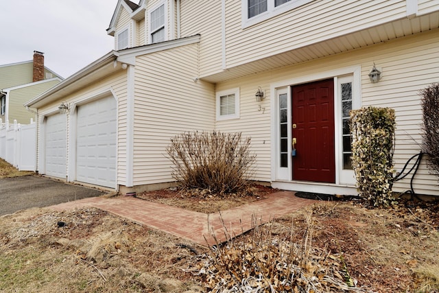 view of exterior entry with a garage and driveway