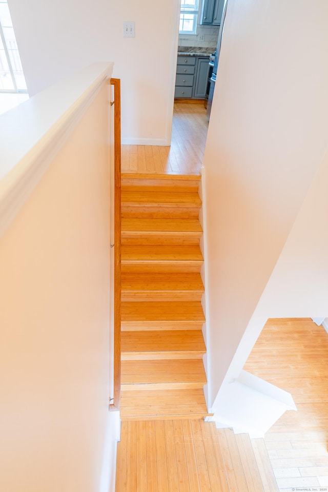 staircase with baseboards and wood-type flooring