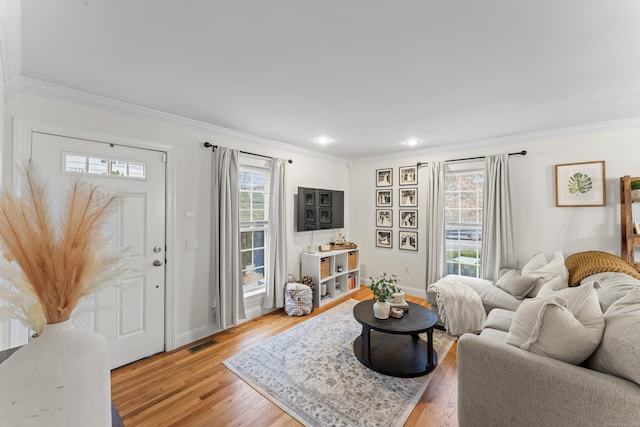 living room with baseboards, light wood-style flooring, and crown molding