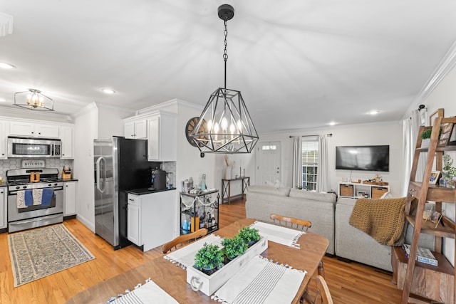 dining area featuring light wood-style floors, recessed lighting, a chandelier, and ornamental molding