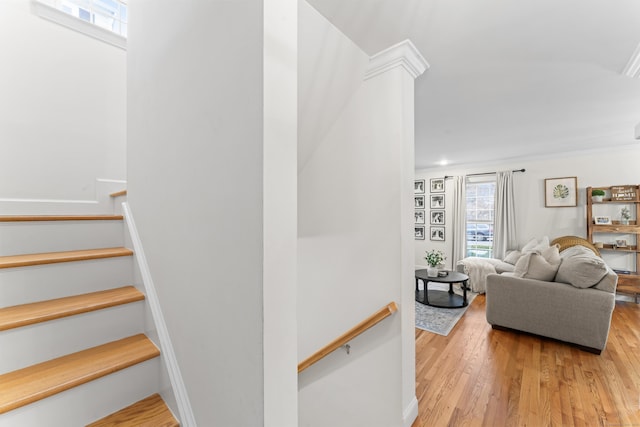 stairs featuring decorative columns and hardwood / wood-style floors