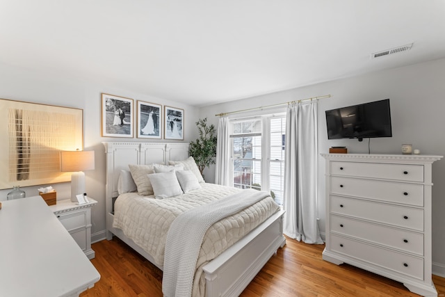 bedroom featuring light wood finished floors and visible vents