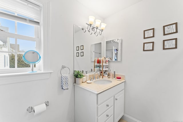 bathroom featuring an inviting chandelier, baseboards, and vanity