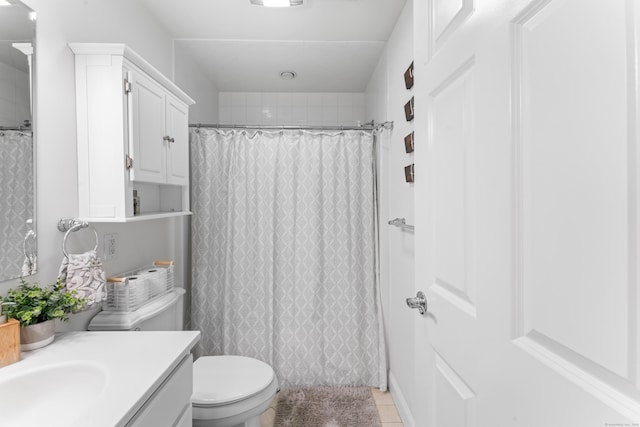 full bathroom featuring tile patterned flooring, curtained shower, vanity, and toilet