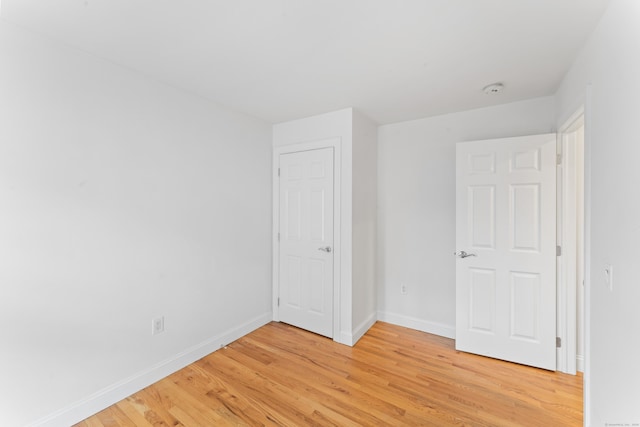 unfurnished bedroom with baseboards and light wood-style floors