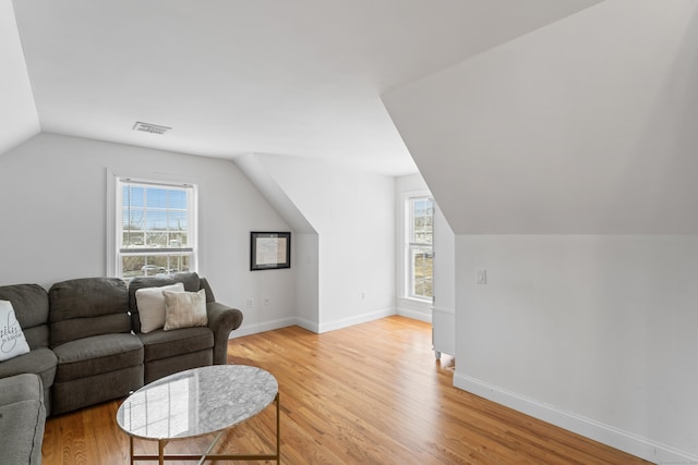 living room featuring light wood-style floors, a healthy amount of sunlight, and visible vents