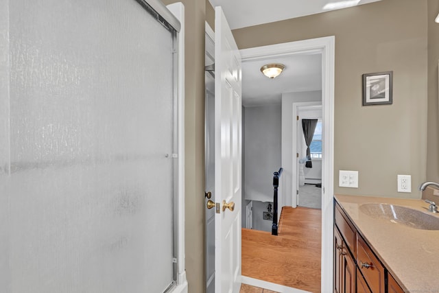 bathroom with a shower with shower door and vanity