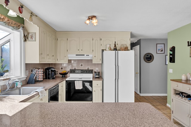 kitchen with range with electric stovetop, tasteful backsplash, freestanding refrigerator, a sink, and under cabinet range hood