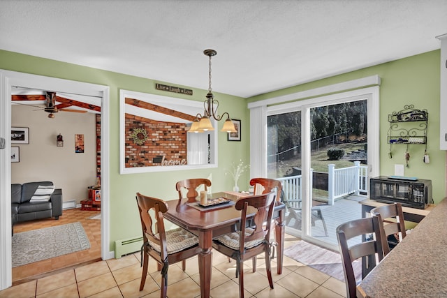 dining room featuring light tile patterned floors, ceiling fan with notable chandelier, a baseboard radiator, and a textured ceiling