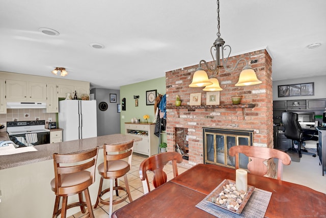 dining area featuring light tile patterned floors and a fireplace