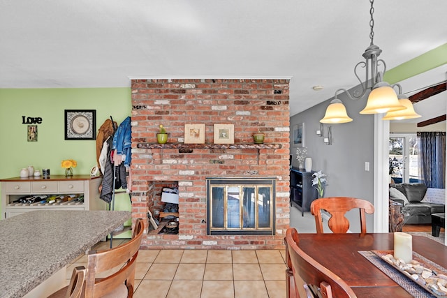 dining space featuring a brick fireplace and light tile patterned flooring