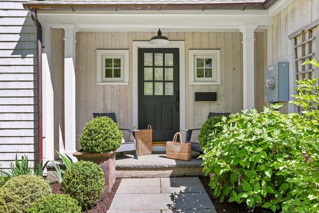 view of exterior entry featuring covered porch