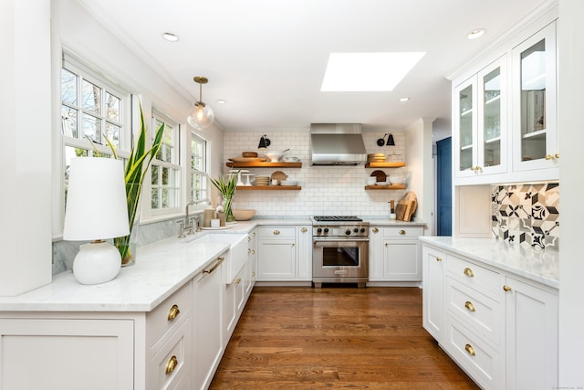 kitchen featuring white cabinets, wall chimney exhaust hood, high end range, open shelves, and a sink