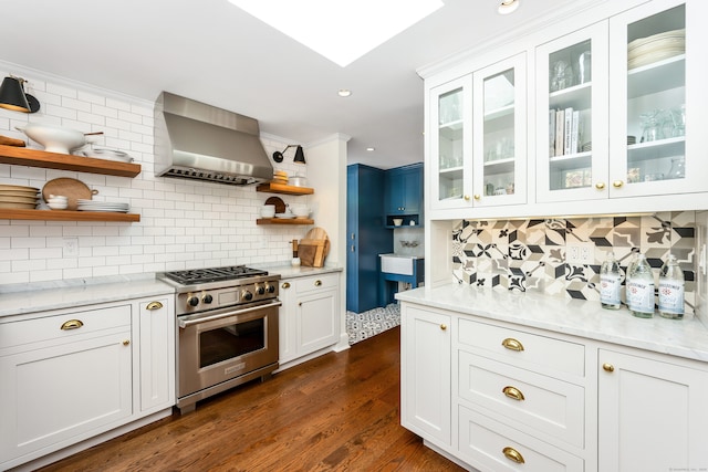 kitchen with decorative backsplash, high end range, dark wood-type flooring, wall chimney range hood, and open shelves