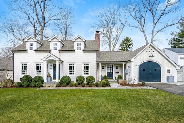 view of front of home featuring a garage, a shingled roof, driveway, a chimney, and a front yard