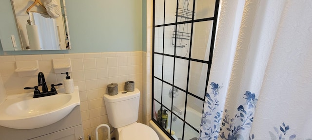 full bathroom featuring curtained shower, vanity, toilet, and tile walls