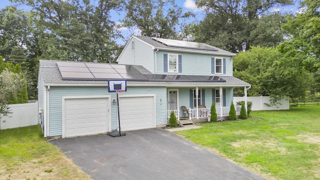 view of front facade featuring an attached garage, fence, roof mounted solar panels, a porch, and a front yard