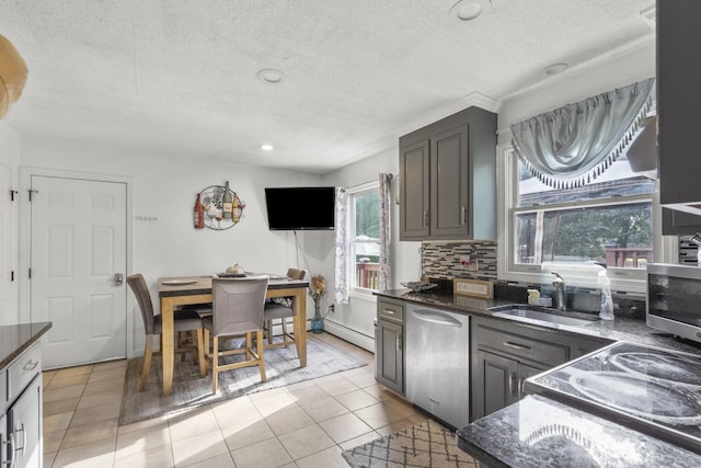 kitchen featuring light tile patterned floors, decorative backsplash, dark stone counters, stainless steel appliances, and a sink