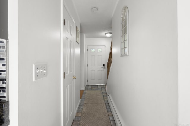 hallway featuring baseboards and stairs