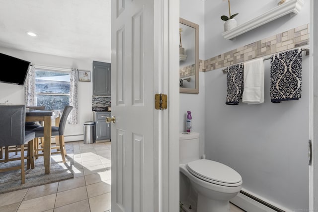 bathroom with toilet, tasteful backsplash, a baseboard heating unit, and tile patterned flooring