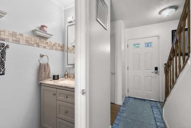 interior space with a textured ceiling, stairway, and crown molding