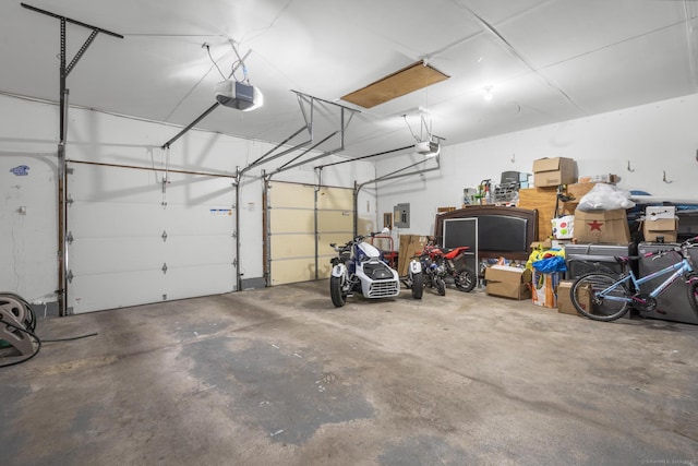 garage with a garage door opener and electric panel