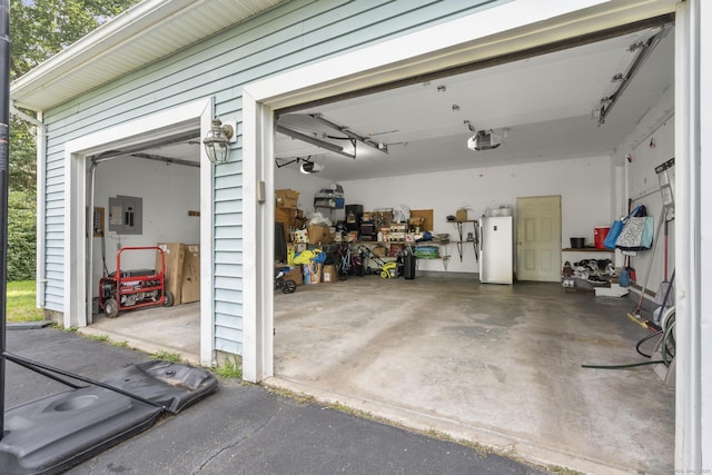 garage with water heater, electric panel, and a garage door opener