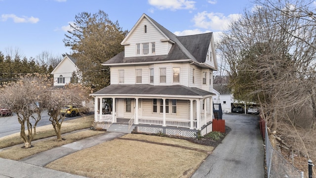 view of front of home featuring covered porch, a shingled roof, and aphalt driveway