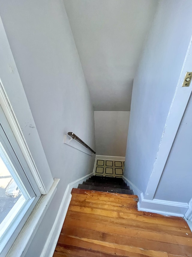 stairs with wood finished floors and baseboards