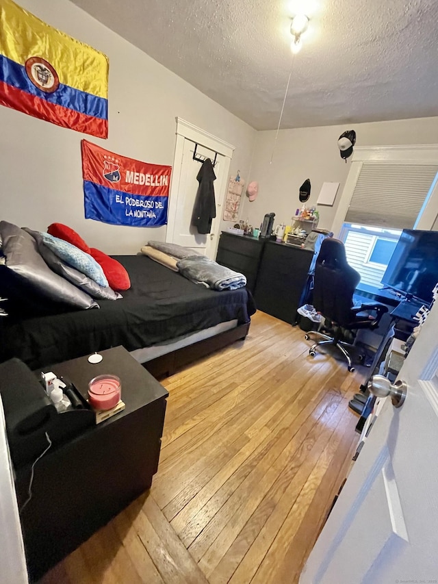 bedroom featuring a textured ceiling and hardwood / wood-style floors