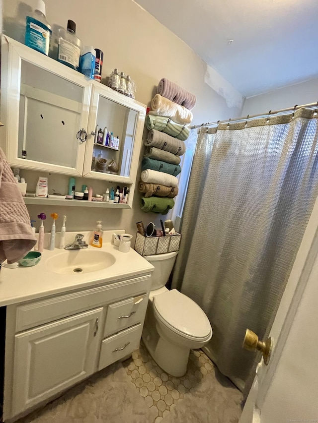 bathroom with toilet, a shower with curtain, tile patterned floors, and vanity