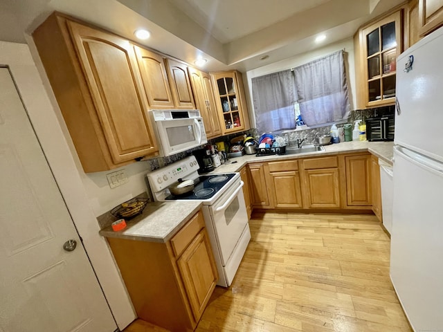 kitchen featuring white appliances, light wood-style flooring, glass insert cabinets, light countertops, and recessed lighting