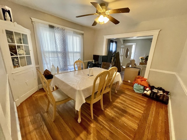 dining space featuring a ceiling fan and wood finished floors