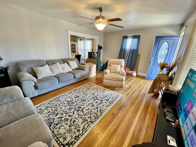 living room featuring ceiling fan, wood finished floors, and baseboards