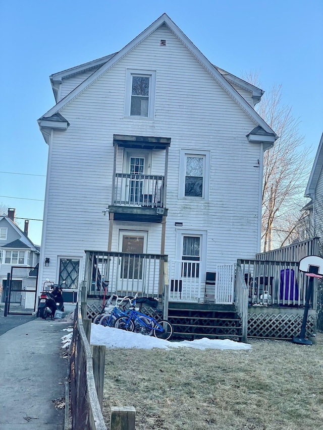 rear view of property featuring fence and a balcony