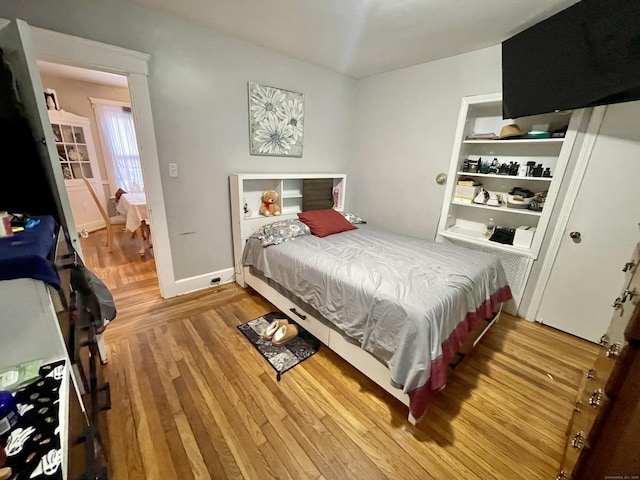 bedroom featuring baseboards and wood finished floors