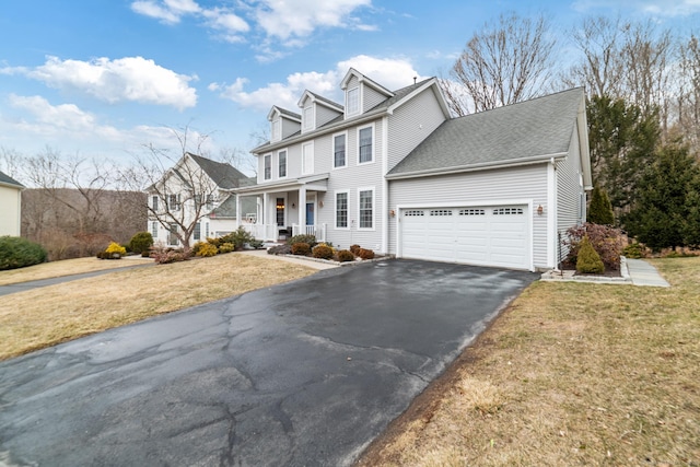 view of front facade featuring a garage, covered porch, driveway, and a front lawn