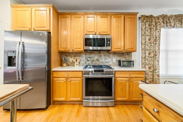 kitchen featuring stainless steel appliances, light countertops, and light wood-style flooring