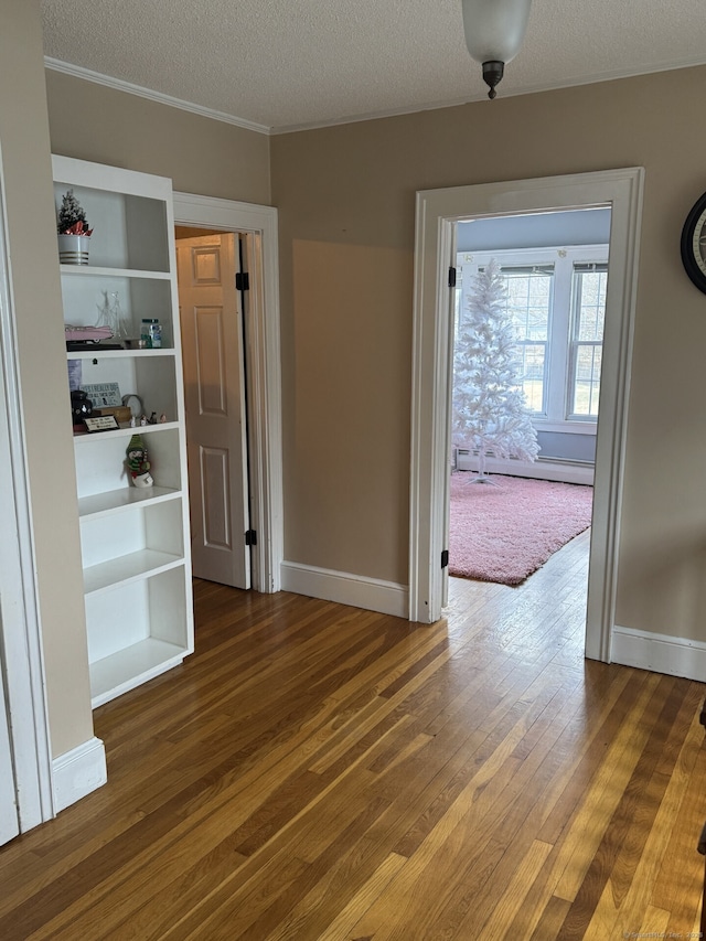 unfurnished dining area featuring hardwood / wood-style flooring, a baseboard radiator, baseboards, and a textured ceiling