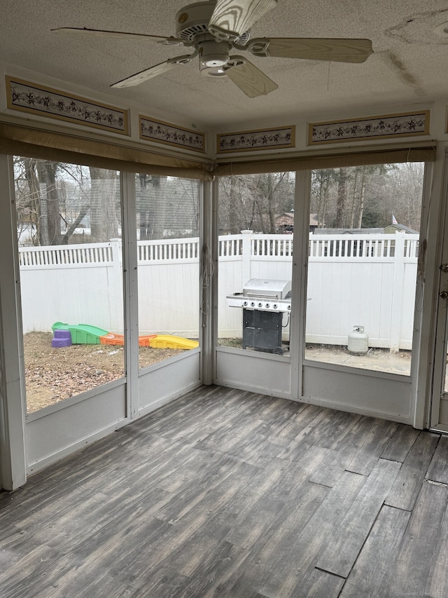 unfurnished sunroom featuring ceiling fan