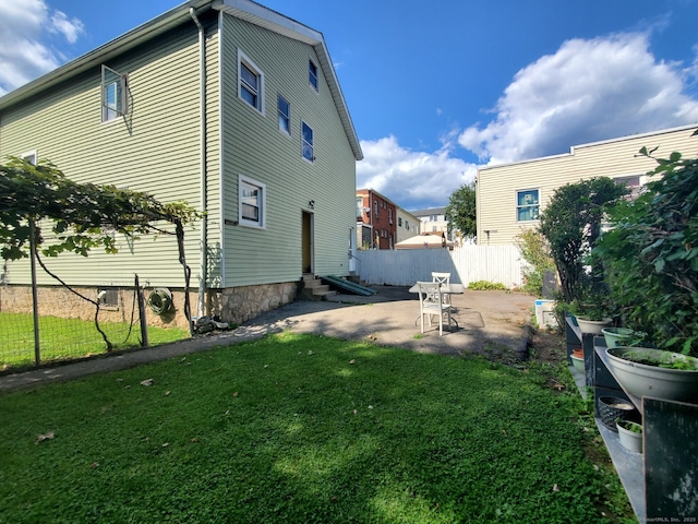 exterior space with a patio area, entry steps, a yard, and fence