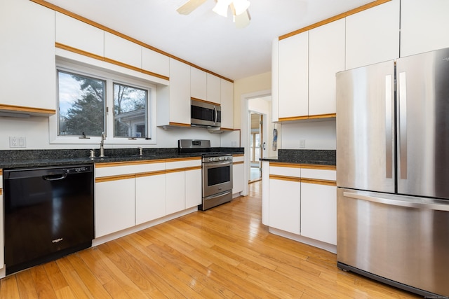 kitchen with a sink, white cabinets, light wood-style floors, and stainless steel appliances