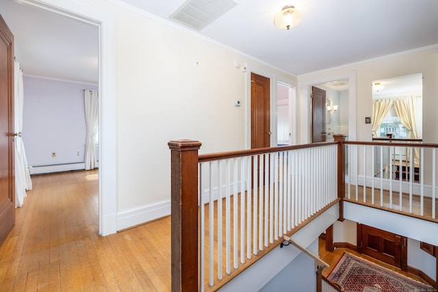 corridor featuring ornamental molding, an upstairs landing, visible vents, and a baseboard radiator