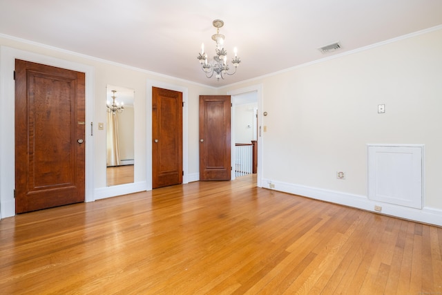 spare room with visible vents, crown molding, light wood finished floors, a baseboard radiator, and a chandelier